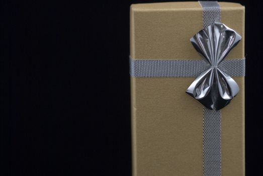 Christmas gift with silver bow on black background