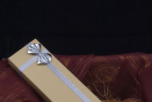 Christmas gift with silver bow on black background