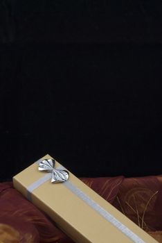 Christmas gift with silver bow on black background