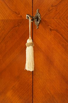 Bronze key with a tassel in a keyhole