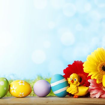 Easter eggs, flowers and chick aber green grass background