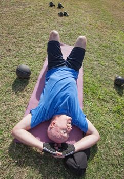 Tired mature man laying on mat outdoors