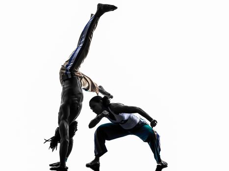 two people couple capoeira dancers dancing in silhouette studio isolated on white background