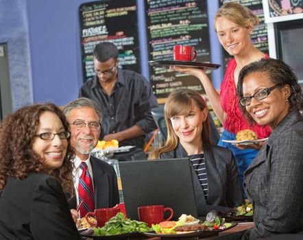 Happy group of people with laptop in cafe and barista