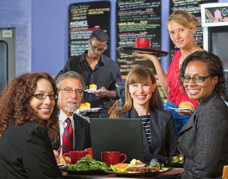 Smiling executives with attractive server in coffee house