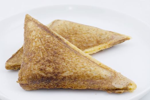 A Cheese and Onion toasted sandwich on white plate