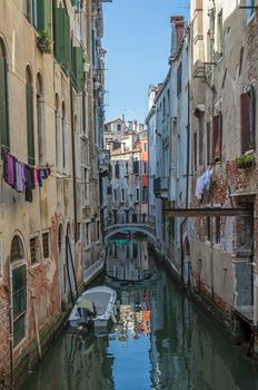 Bridge, boat and a canal in Venice, Italy.