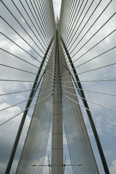 Modern Architctureal style bridge abstracts angainst a cloudy sky
