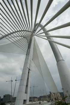 Modern Architctureal style bridge abstracts angainst a cloudy sky
