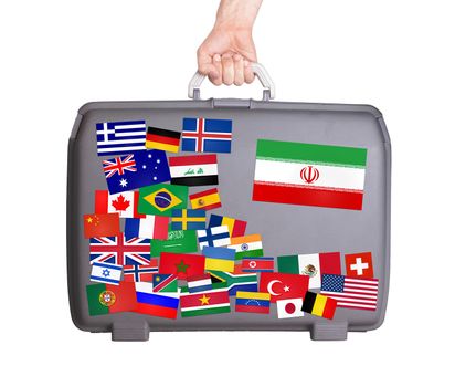 Used plastic suitcase with lots of small stickers, large sticker of Iran