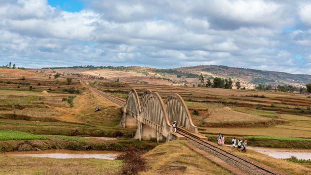 Malagasy people from the countryside cross a railroad bridge on the way to work and school on May 25, 2014 in Madagascar.