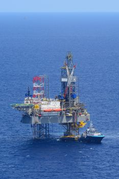 The offshore drilling oil rig and supply boat side view from aircraft.
