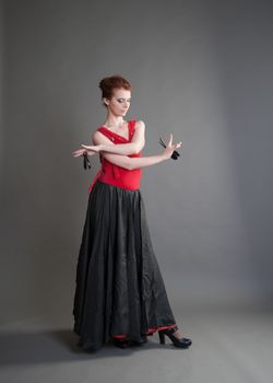 flamenco dancer swinging skirt on a grey background