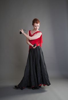 flamenco dancer swinging skirt on a grey background