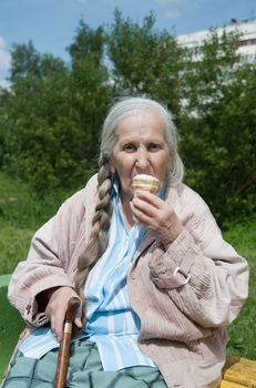 old grandmother to eat ice cream in the summer in the Park