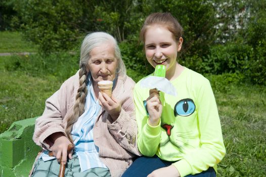 grandmother with her granddaughter, eating ice cream in the summer