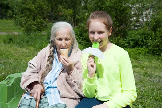 grandmother with her granddaughter, eating ice cream in the summer