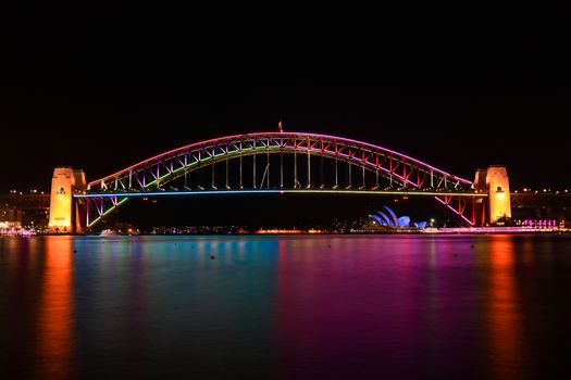 SYDNEY, AUSTRALIA - JUNE 2, 2014;  Sydney Harbour bridge iilluminated n various vibrant colours and water reflections,during Vivid Sydney snnual festival events.