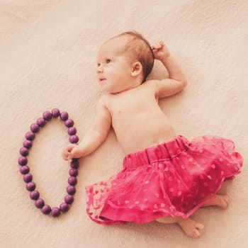newborn baby girl in skirt with beads