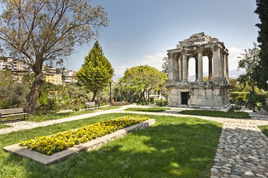 The Mausoleum lies in the Street of  gumuskesen and is well known for being a Roman version of the Halikarnassos Mausoleion, which was recognized as one of the seven wonders of the ancient era. Since the Mausoleum was constructed on the most attractive site in the Roman Necropolis, there was a principle that forced the owner of the building to be an important person for the city. Namely, the owner of this place was expected to be a noble man, a manager or a person recognized as the member of a royal family. This mausoleum, being an exemplary construction thanks to the embellishing stonemasonry and the plan schedule, was constructed in the 2nd century AD, when the Antonins were ruling over Rome. The mausoleum consists of three divisions: (1) the ground floor that serves as a funerary chamber, (2) the second floor that represents the peristillium and the (3) pyramidal top floor. The walls of the ground floor consist of perfectly caved large marble blocks. The coating style of the gate in this construction is based on the same coating technique that was used for the Baltali Gate. The roof of the mausoleum was enriched from one end until the other thanks to relief plants and flowers and geometric motives. People make effort so that the gumuskesen Mausoleum, which represents the Roman Period, takes its place in the ‚ÄúWord Heritage List‚Äù that has been prepared by UNESCO.