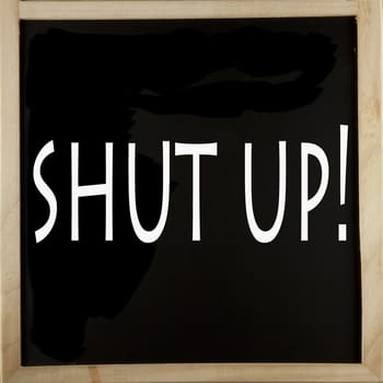 Words "Shut up" written with chalk over a blackboard