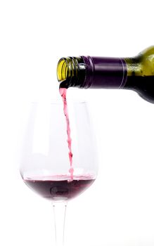 Red wine pouring into a glass on white background