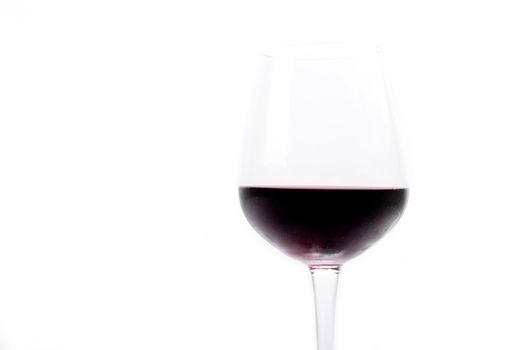 Red wine pouring in a wineglass on white background