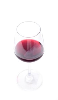 Red wine pouring in a wineglass on white background