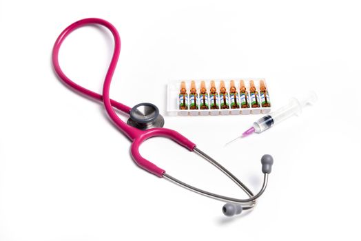 ampule syringe and stethoscope on white table