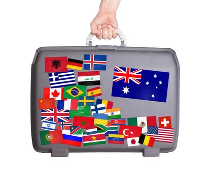Used plastic suitcase with lots of small stickers, large sticker of Australia