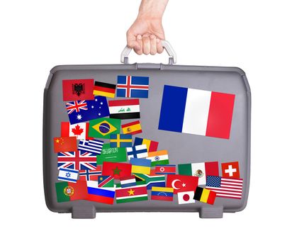 Used plastic suitcase with lots of small stickers, large sticker of France