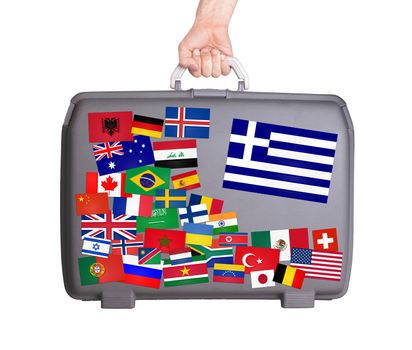 Used plastic suitcase with lots of small stickers, large sticker of Greece