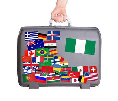 Used plastic suitcase with lots of small stickers, large sticker of Nigeria