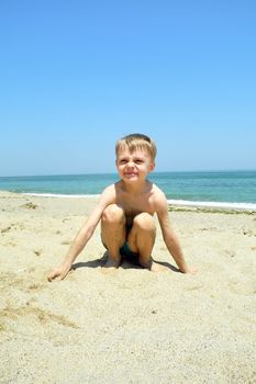    boy plays ashore Black epidemic deathes with sand                            