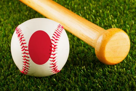 Baseball with Japan flag and bat over a background of green grass