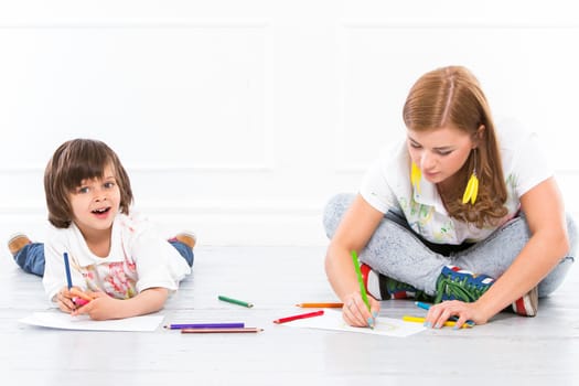 Cute, adorable boy with pencils on the floor