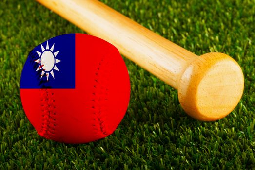 Baseball with Taiwan flag and bat over a background of green grass