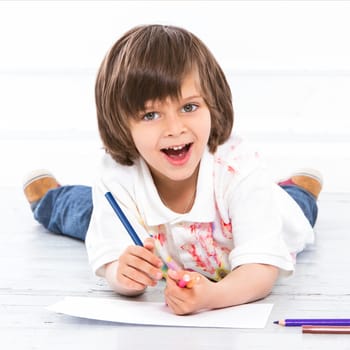 Cute, adorable boy with pencils on the floor