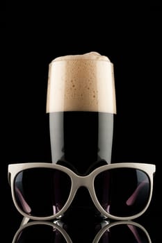 glass of black beer with white sunglass