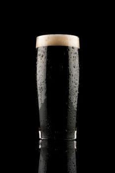 glass of black beer with reflection and water drops