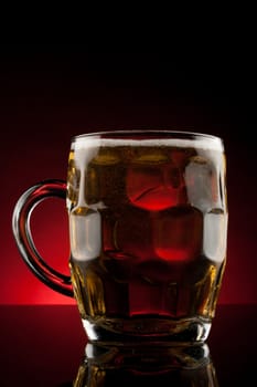 back lit glass mug with beer with reflection