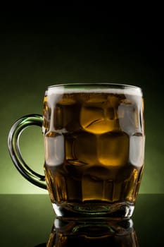 back lit glass mug with beer with reflection