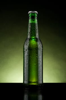 back lit green beer bottle with water drops