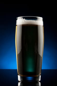 back lit glass of beer with reflection