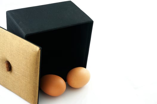 Eggs in a black box, with the lid brown. A symbol of the start of something new.