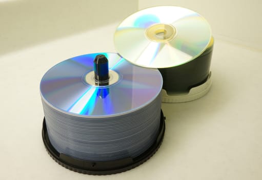 Two stacks of CDs. There are two colors are purple and white, placed on a white marble table.                              