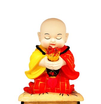 The little monks, wear the yellow and red robe, Chinese style. Hands holding incense is sitting with eyes closed, prayer intentions.