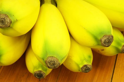 Close up of ripe banana, have large size, gold colour, delicious, and beneficial to the body. Placed on a wooden table.                               