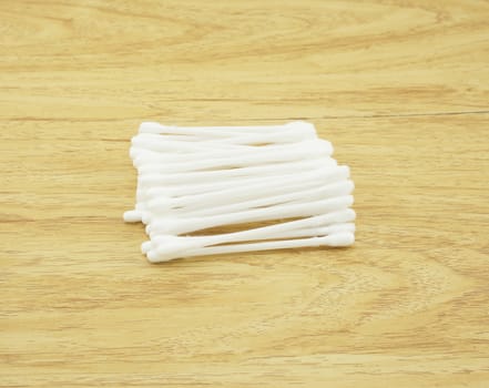 Several of cotton bud, put ogether on the brown wood table.                               