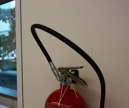 Fire extinguisher prepared in the office, hung on the side wall at work.                               